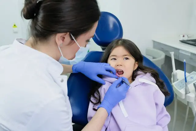 Dentist cleaning the Girl's Teeth